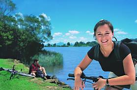 Backpackers enjoying a bike ride next to the Tweed River